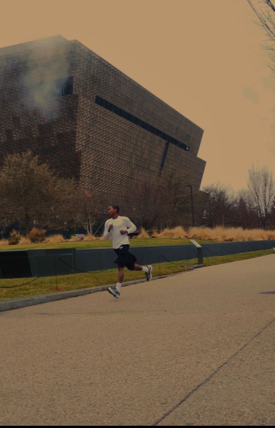 Runner in OS shorts passing a museum